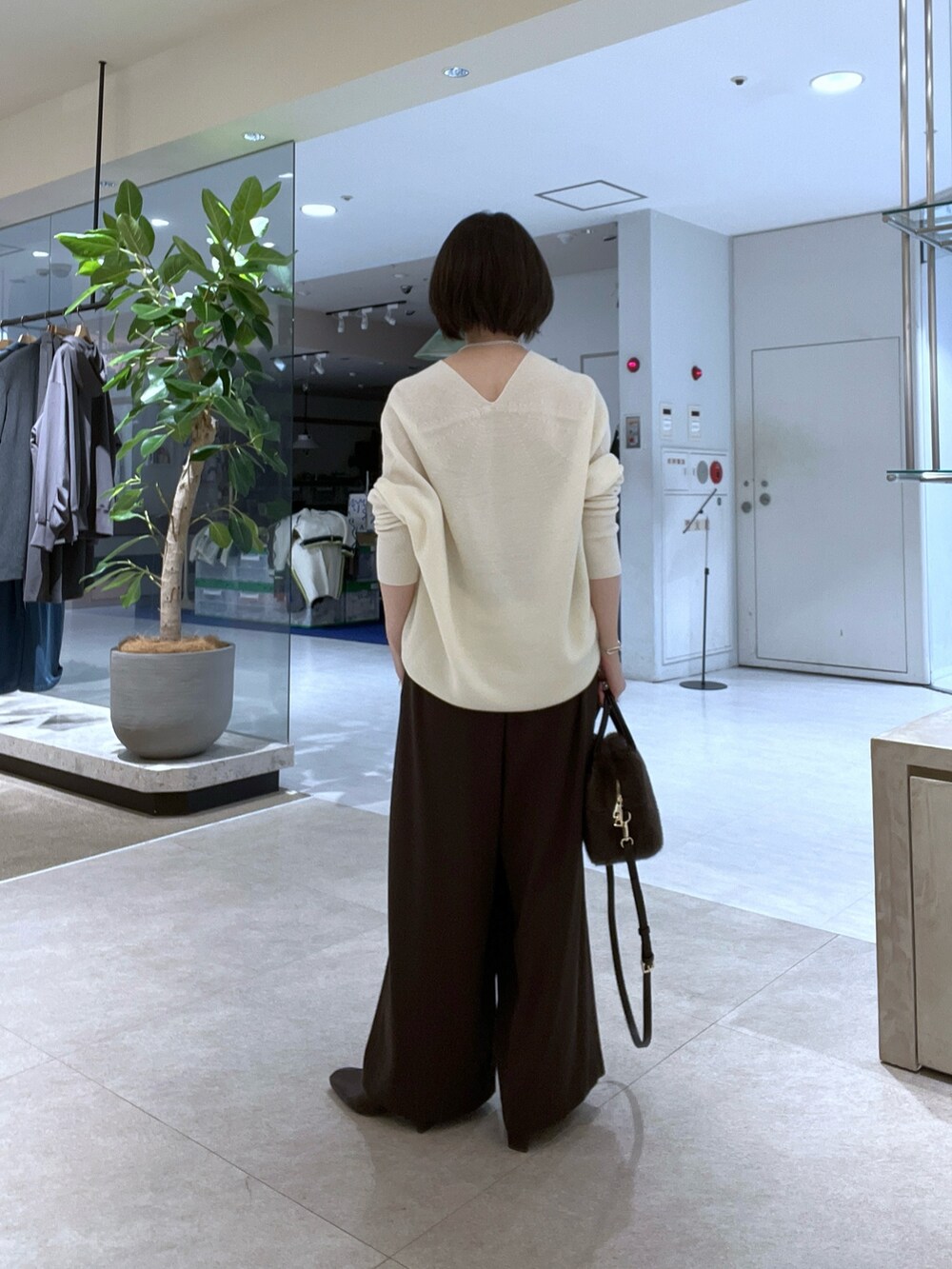 イエロー系のその他アウター、ホワイト系のニット/セーター、ブラウン系のスラックスを着用したレディースの秋コーディネートの7枚目の写真