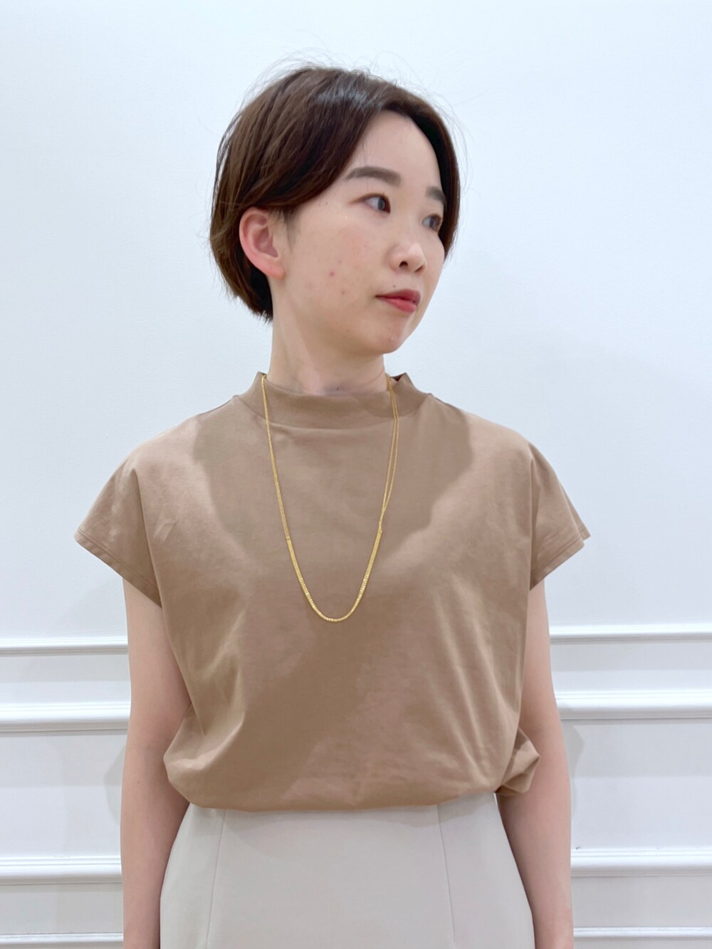 ブラウン系のTシャツ/カットソー、グレー系のスカート、ホワイト系のサンダルを着用したレディースの春コーディネートの3枚目の写真