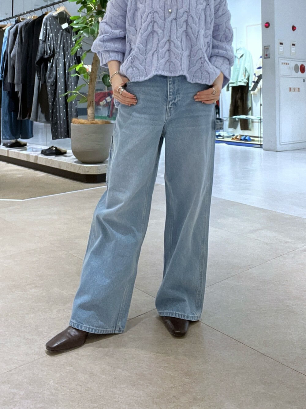 ブルー系のデニムパンツ、ブラウン系のボストンバッグ、ブラウン系のブーツを着用したレディースの秋コーディネートの10枚目の写真