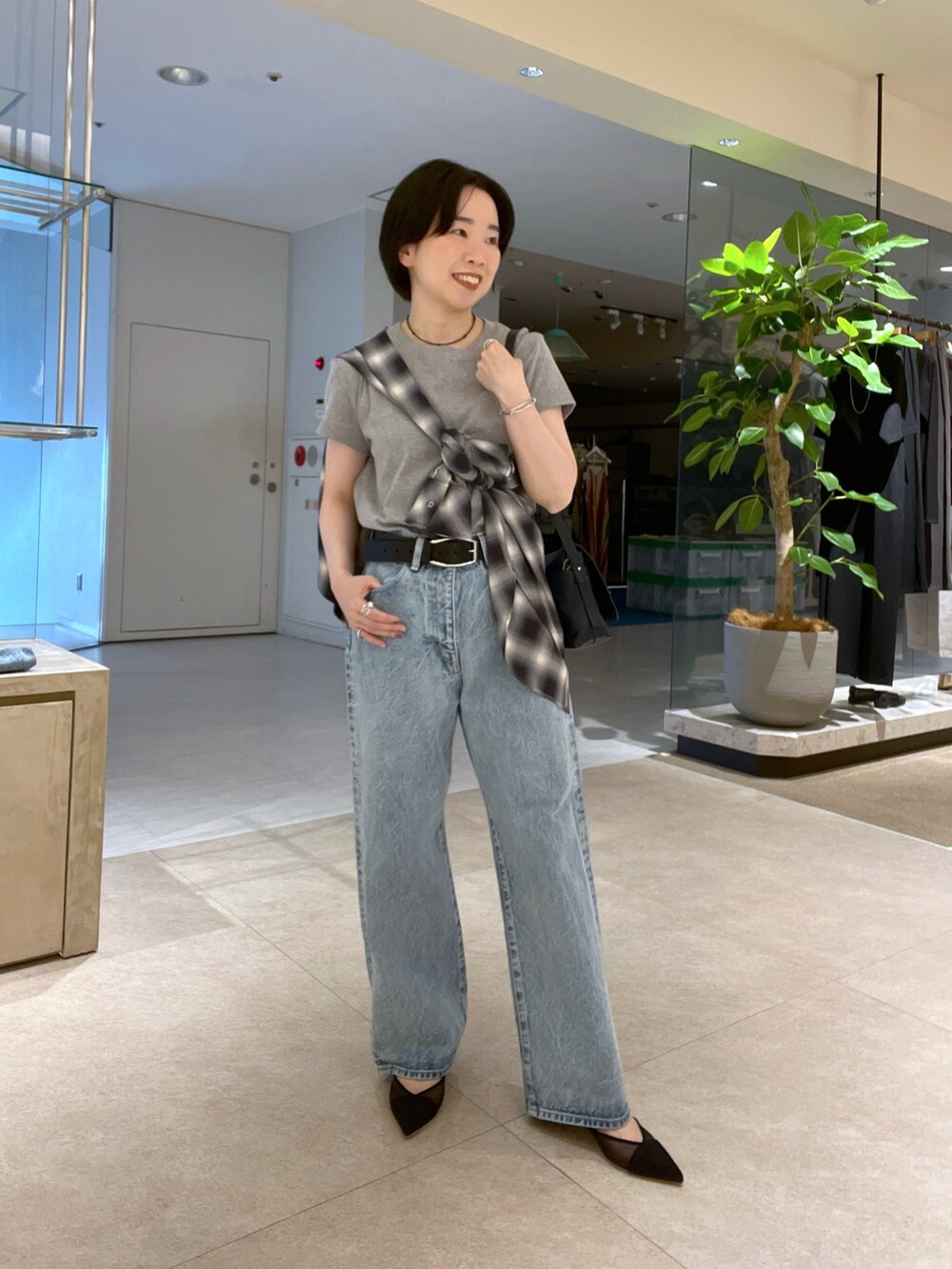 グレー系のTシャツ/カットソー、ブルー系のデニムパンツ、ブラック系のパンプスを着用したレディースの夏コーディネートの2枚目の写真