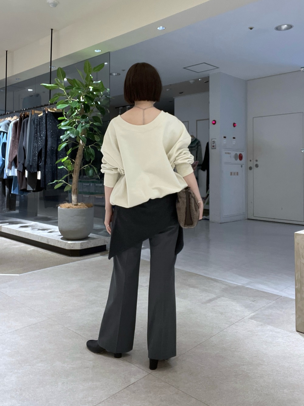 ホワイト系のTシャツ/カットソー、グレー系のその他パンツ、ブラック系のブーツを着用したレディースの冬コーディネートの3枚目の写真