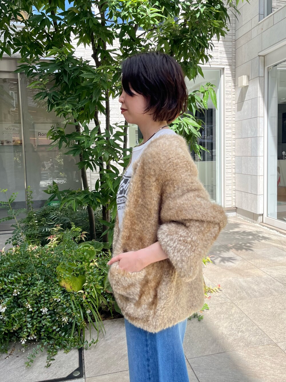 ブルー系のデニムパンツ、ホワイト系のTシャツ/カットソー、ブラック系のボストンバッグを着用したレディースの秋コーディネートの5枚目の写真