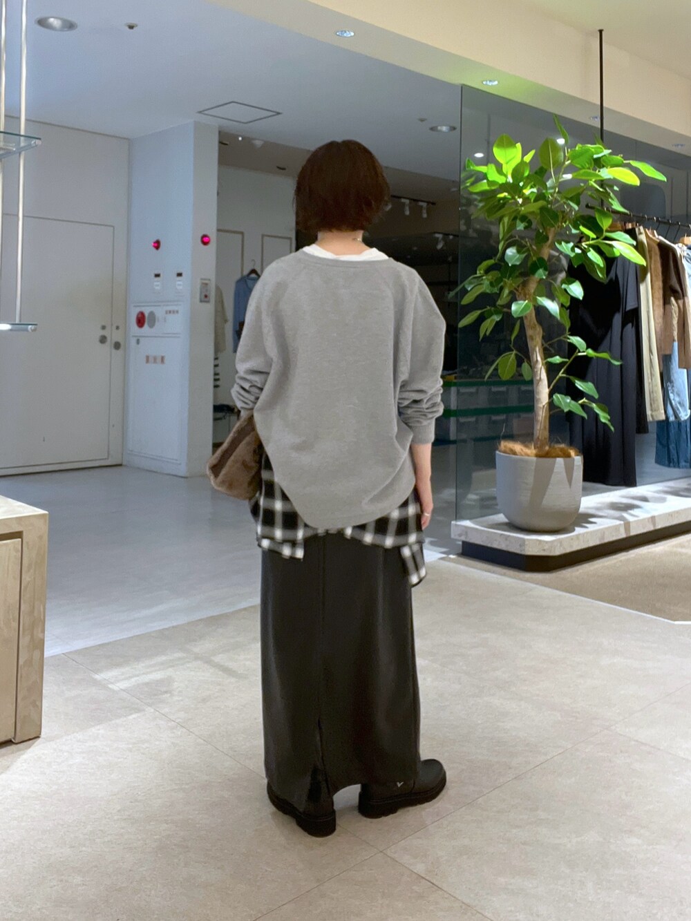 グレー系のスウェット、ブラウン系のハンドバッグ、ブラック系のシャツ/ブラウスを着用したレディースの秋コーディネートの3枚目の写真
