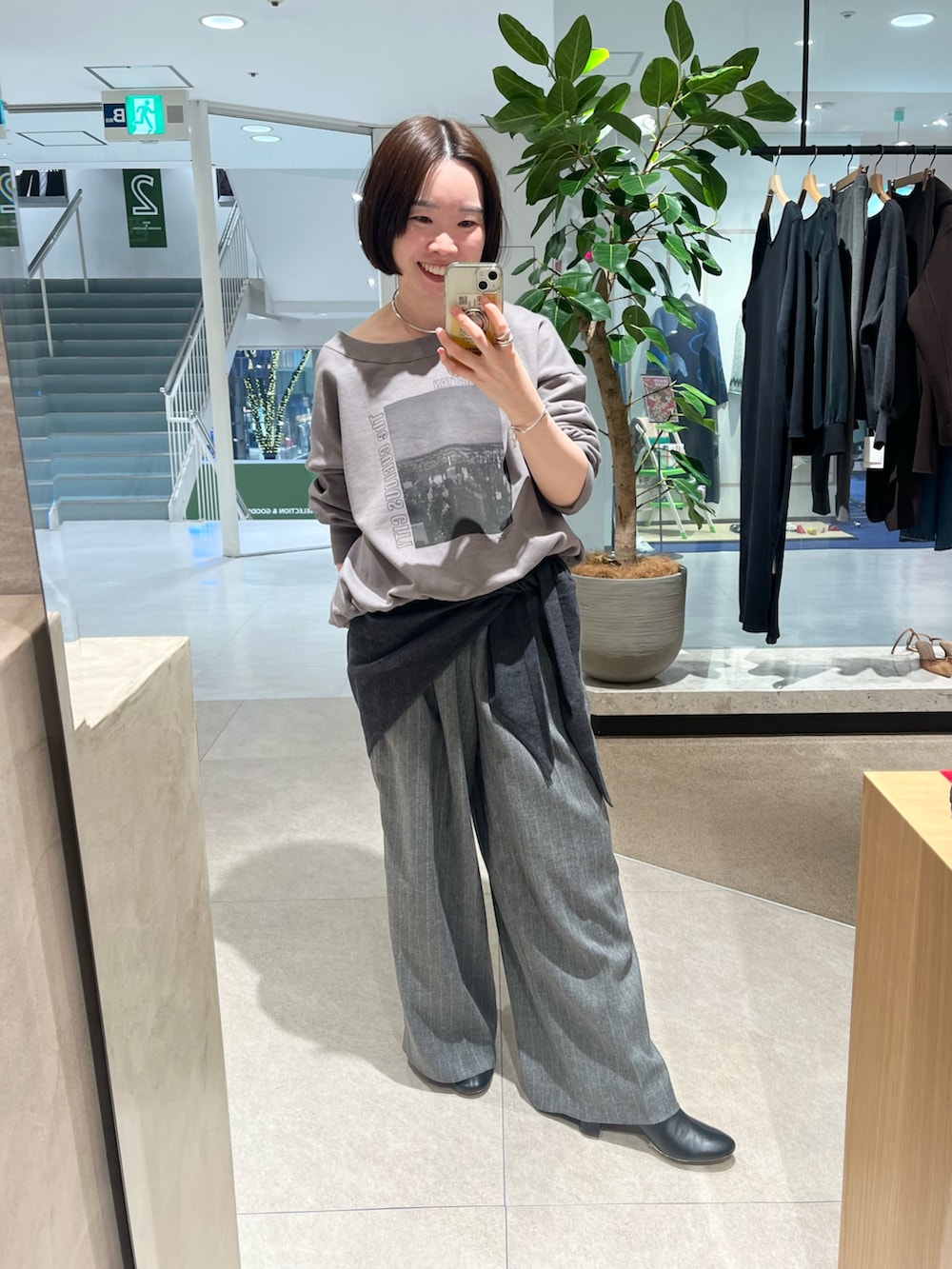 ブラック系のダウンジャケット/コート、グレー系のTシャツ/カットソー、グレー系のスラックスを着用したレディースの冬コーディネートの3枚目の写真