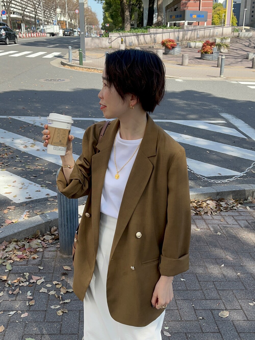 ブラウン系のテーラードジャケット、ホワイト系のTシャツ/カットソー、ホワイト系のスカートを着用したレディースの春コーディネートの2枚目の写真