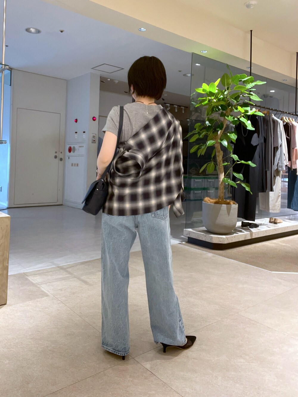 グレー系のTシャツ/カットソー、ブルー系のデニムパンツ、ブラック系のパンプスを着用したレディースの夏コーディネートの4枚目の写真