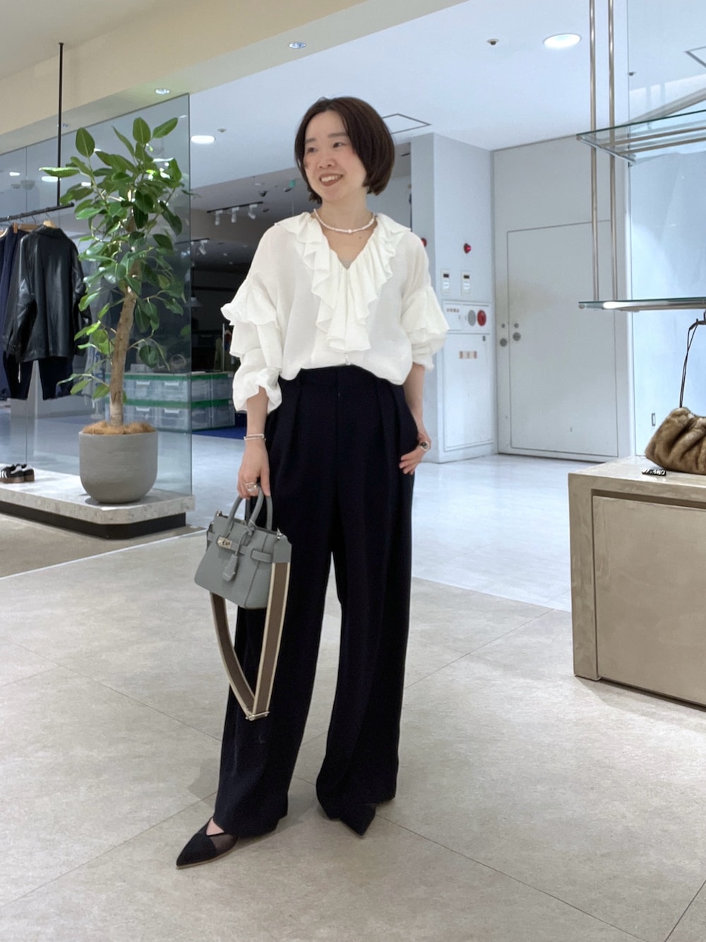 グレー系のテーラードジャケット、ホワイト系のシャツ/ブラウス、ブルー系のスラックスを着用したレディースの冬コーディネートの6枚目の写真