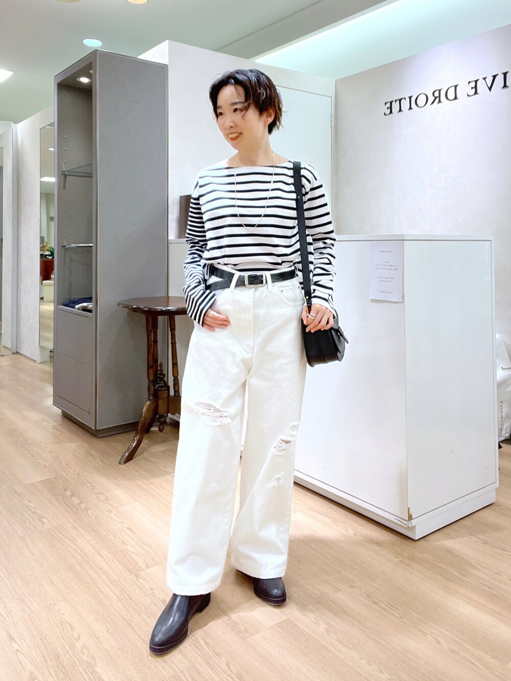ホワイト系のデニムパンツ、ベージュ系のトレンチコート、ブラック系のTシャツ/カットソーを着用したレディースの冬コーディネートの4枚目の写真