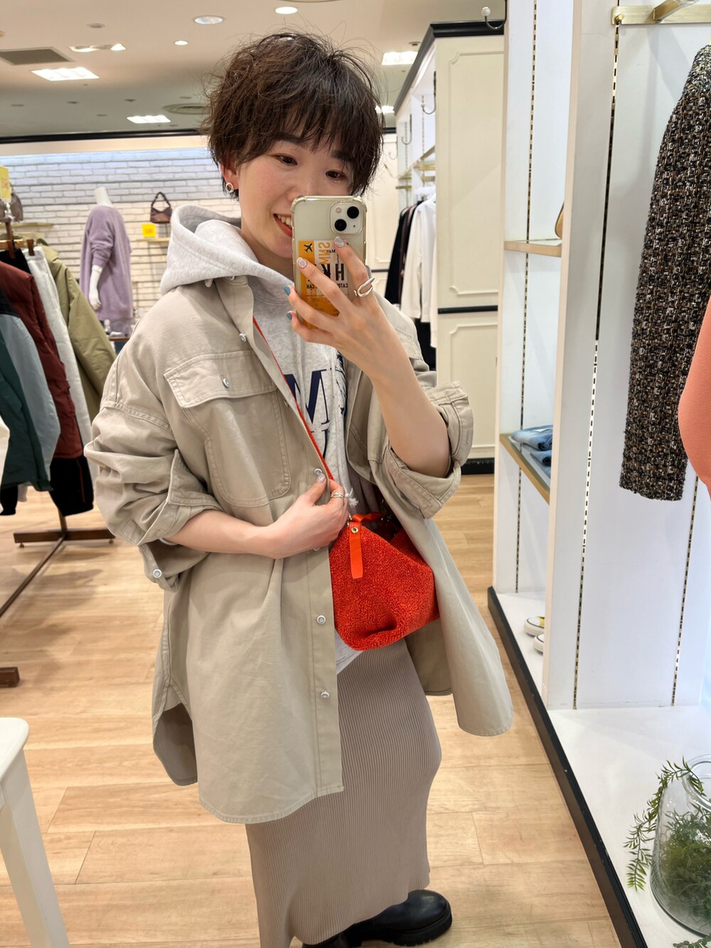 グレー系のTシャツ/カットソー、ベージュ系のシャツ/ブラウス、オレンジ系のハンドバッグを着用したレディースの冬コーディネートの2枚目の写真