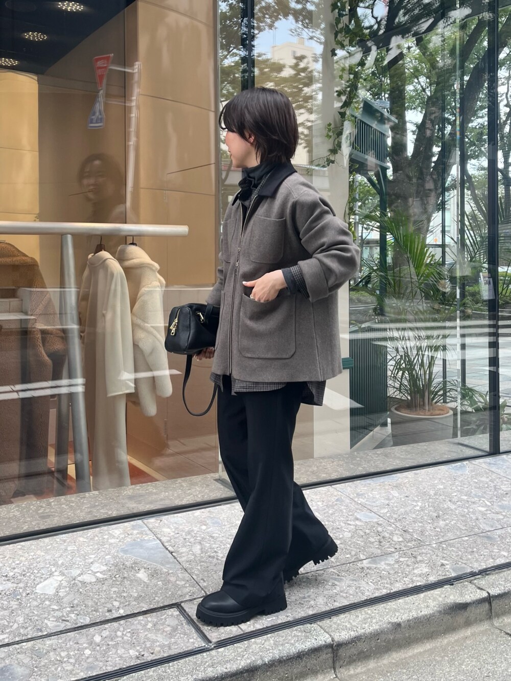 グレー系のニット/セーター、ブラック系のシャツ/ブラウス、ブラック系のブーツを着用したレディースの夏コーディネートの2枚目の写真