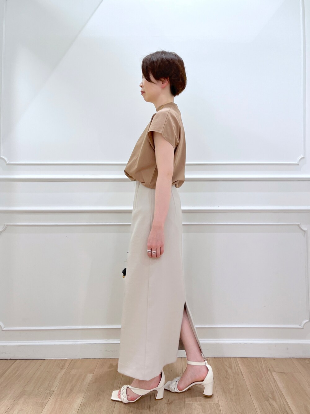 ブラウン系のTシャツ/カットソー、グレー系のスカート、ホワイト系のサンダルを着用したレディースの春コーディネートの2枚目の写真