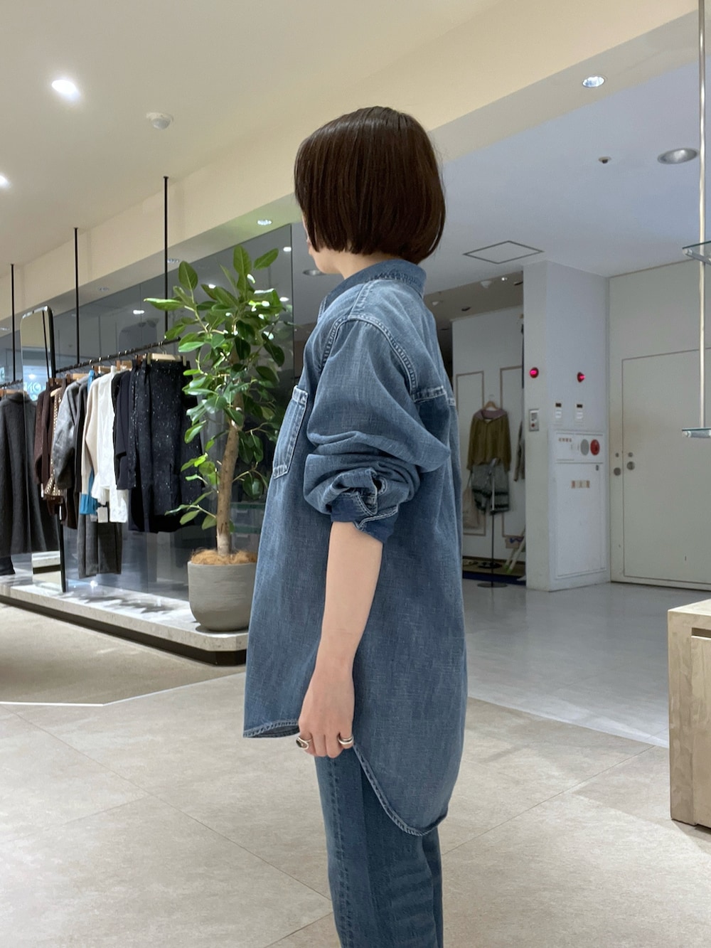 ブルー系のシャツ/ブラウス、ブルー系のデニムパンツ、イエロー系のボストンバッグを着用したレディースの冬コーディネートの5枚目の写真