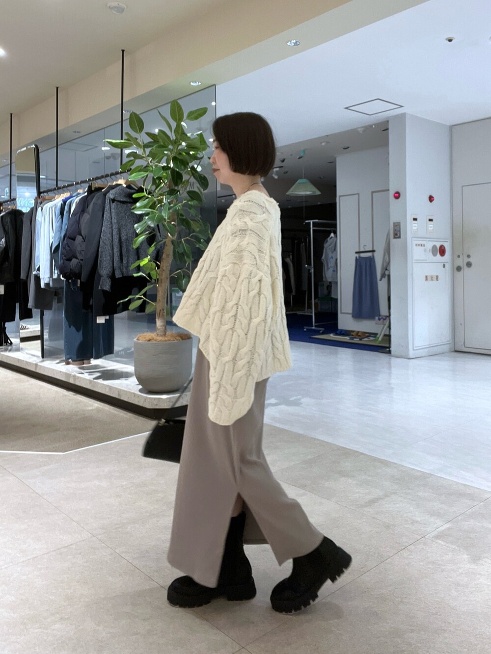 ベージュ系のその他アウター、ホワイト系のニット/セーター、ベージュ系のワンピースを着用したレディースの冬コーディネートの5枚目の写真