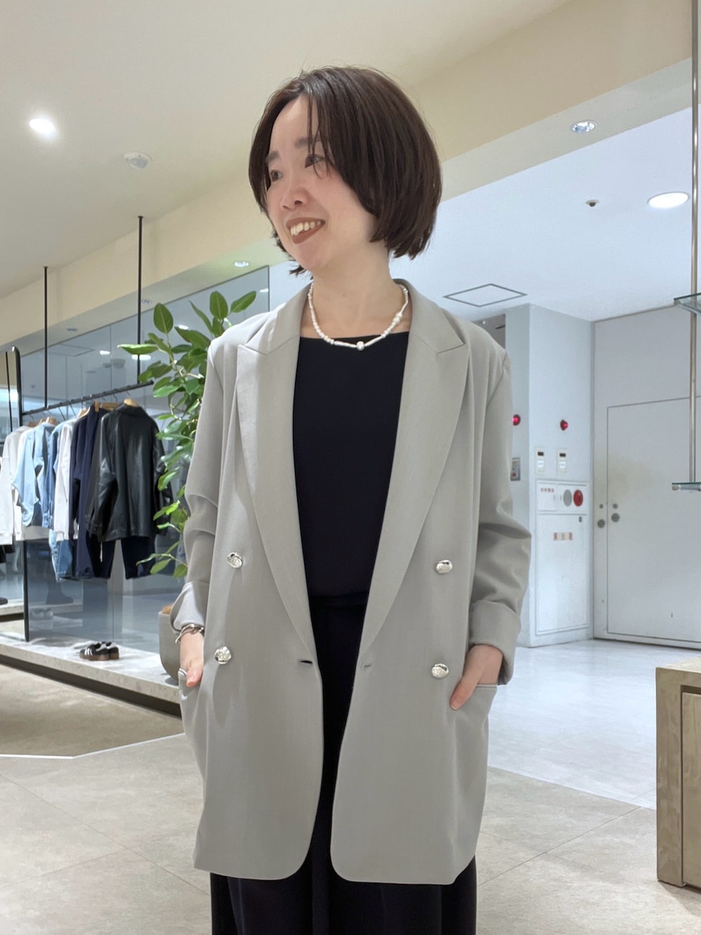 グレー系のテーラードジャケット、ブルー系のスラックス、ブラック系のボストンバッグを着用したレディースの冬コーディネートの4枚目の写真