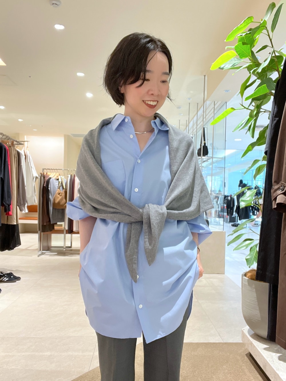 ブルー系のシャツ/ブラウス、グレー系のその他パンツ、ブラウン系のハンドバッグを着用したレディースの秋コーディネートの4枚目の写真