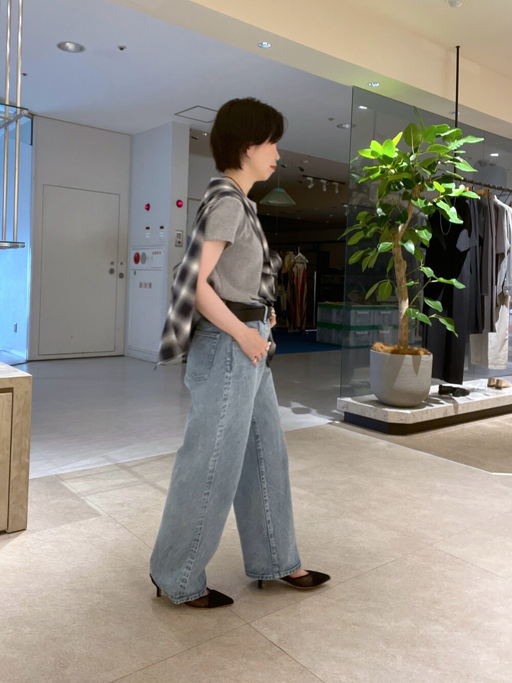 グレー系のTシャツ/カットソー、ブルー系のデニムパンツ、ブラック系のパンプスを着用したレディースの夏コーディネートの3枚目の写真