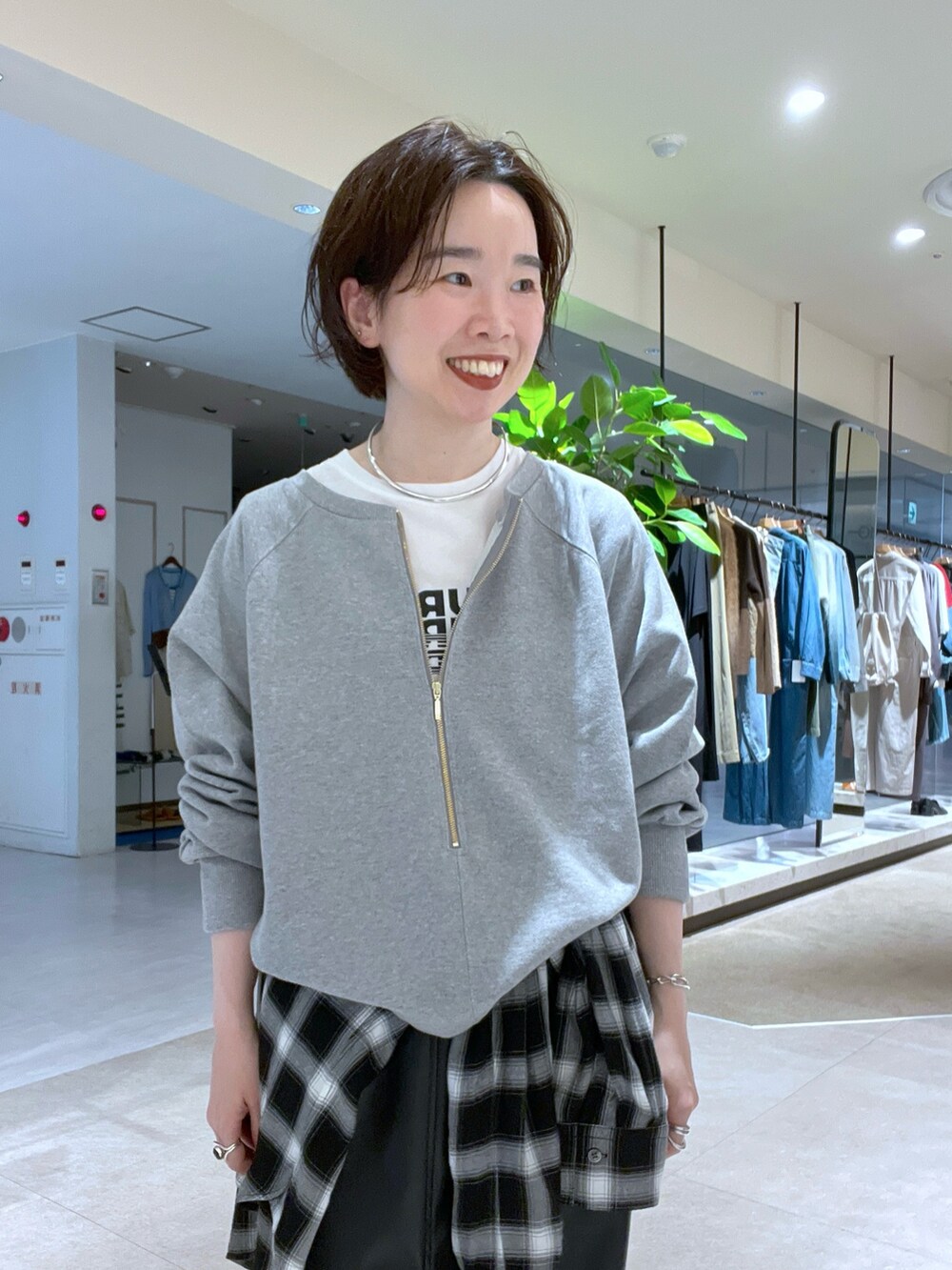 グレー系のスウェット、ブラウン系のハンドバッグ、ブラック系のシャツ/ブラウスを着用したレディースの秋コーディネートの4枚目の写真