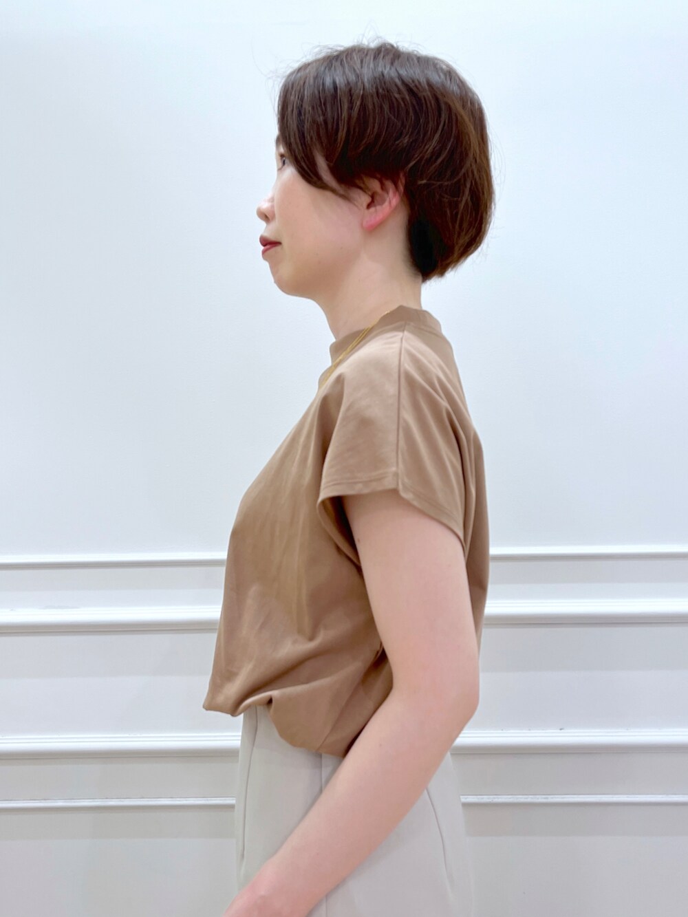 ブラウン系のTシャツ/カットソー、グレー系のスカート、ホワイト系のサンダルを着用したレディースの春コーディネートの4枚目の写真