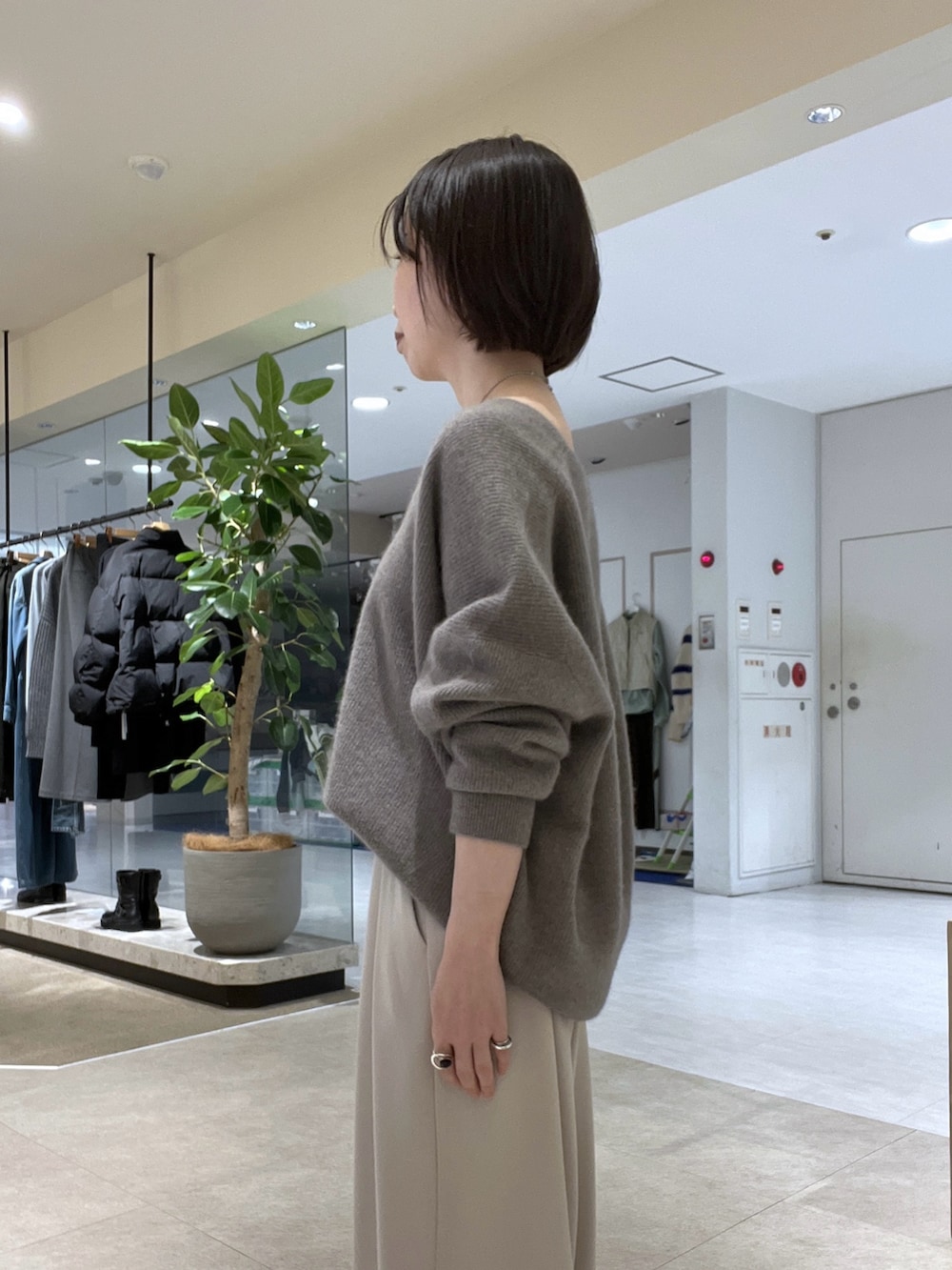 グレー系のニット/セーター、グレー系のスラックス、ベージュ系のハンドバッグを着用したレディースの冬コーディネートの5枚目の写真