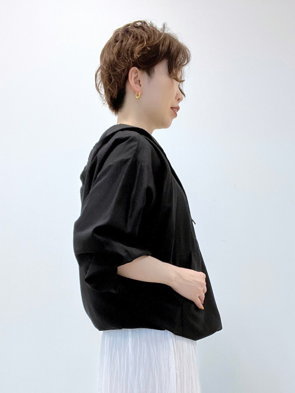 ホワイト系のスカート、ブラック系のシャツ/ブラウス、グリーン系のTシャツ/カットソーを着用したレディースの夏コーディネートの3枚目の写真