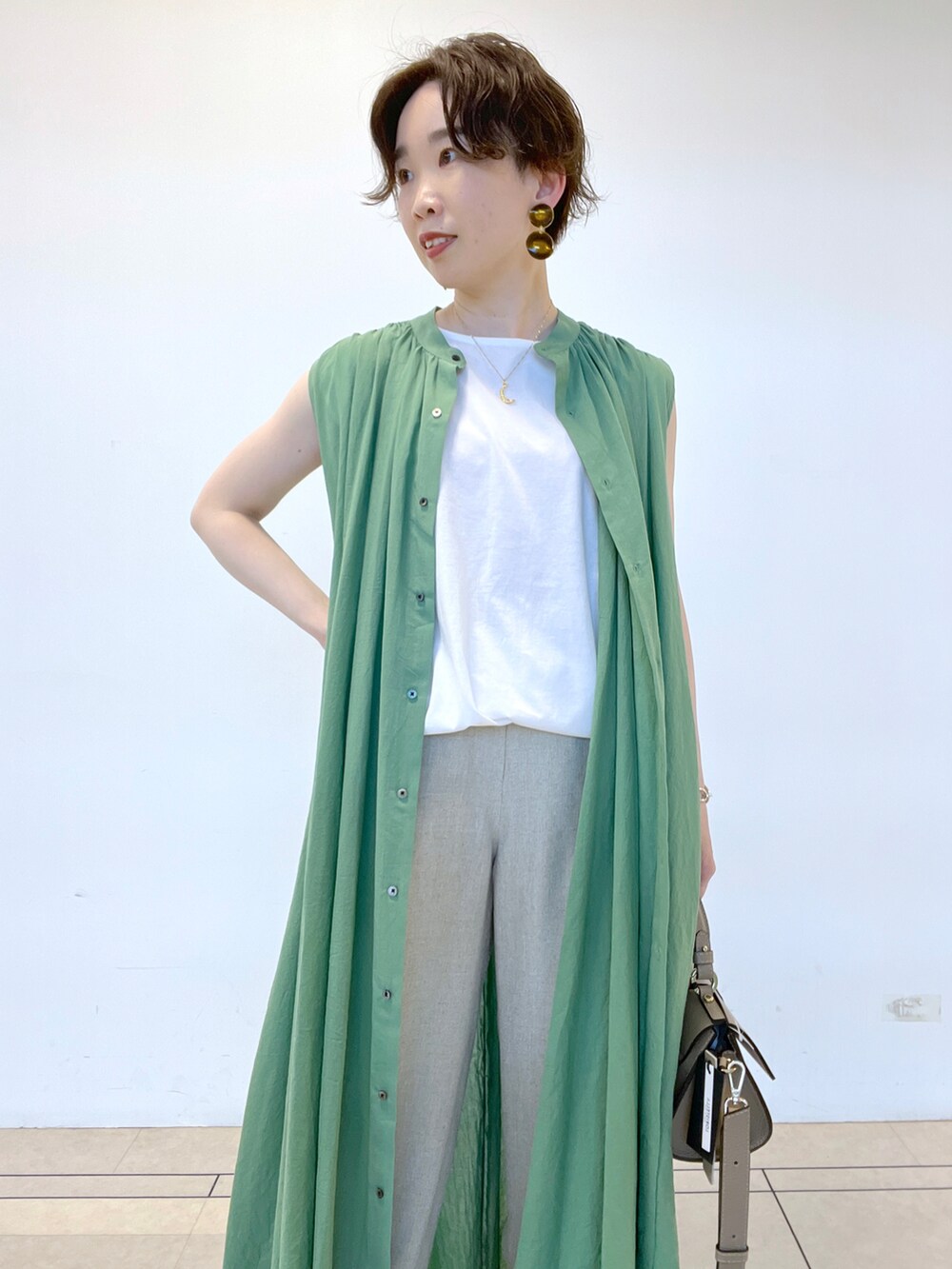 ホワイト系のTシャツ/カットソー、グリーン系のワンピース、ベージュ系のその他パンツを着用したレディースの春コーディネートの4枚目の写真