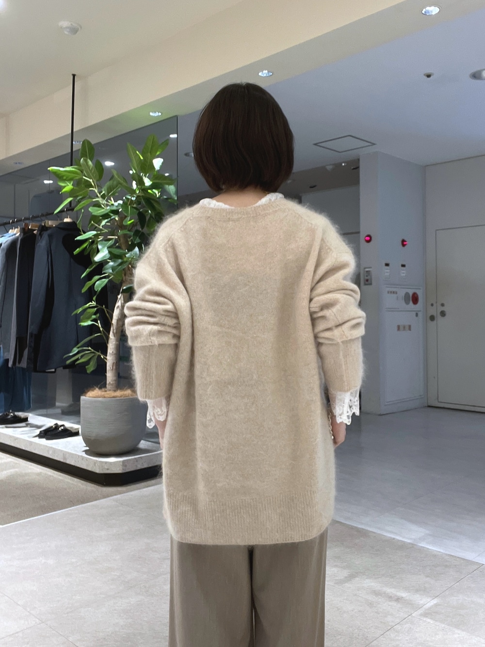 ベージュ系のスラックス、ブラウン系のトートバッグ、ブラウン系のブーツを着用したレディースの秋コーディネートの6枚目の写真