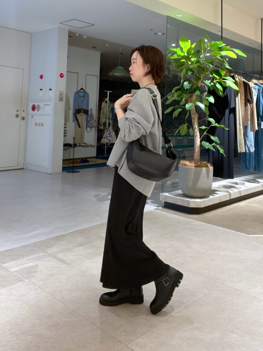 ブラック系のワンピース、グレー系のスウェット、ブラック系のショルダーバッグを着用したレディースの秋コーディネートの2枚目の写真