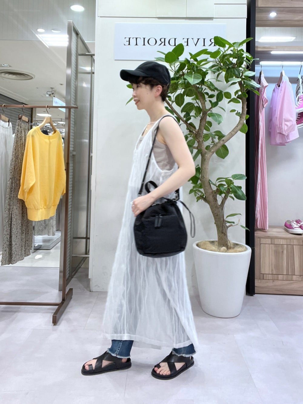 ブルー系のデニムパンツ、ブラウン系のテーラードジャケット、ベージュ系のタンクトップを着用したレディースの春コーディネートの4枚目の写真