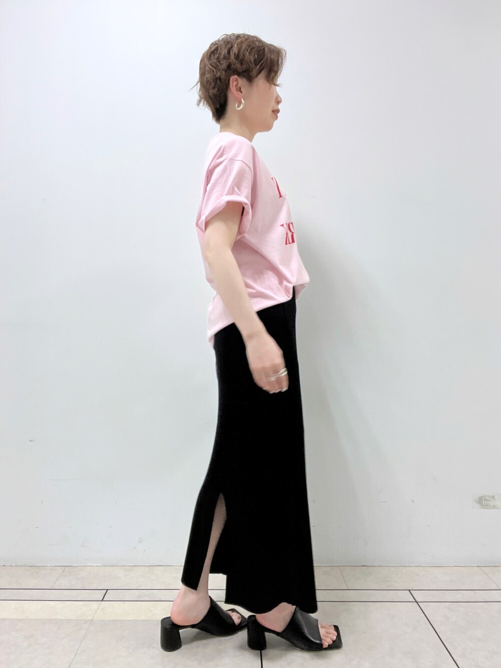 ピンク系のTシャツ/カットソー、ブラック系のスカート、ブラック系のハンドバッグを着用したレディースの春コーディネートの2枚目の写真