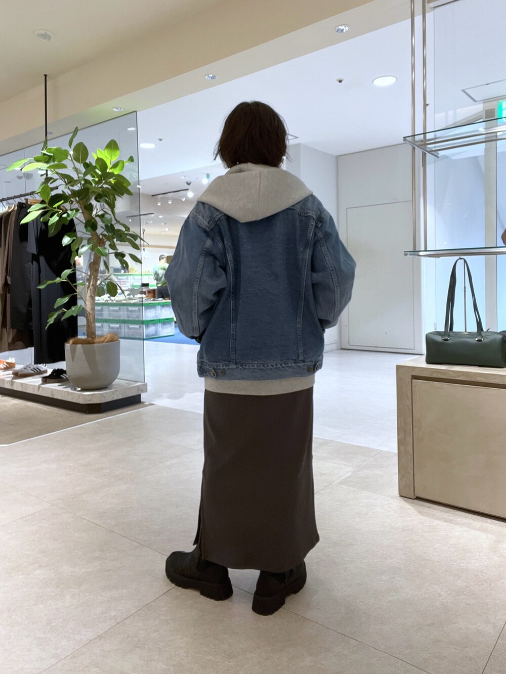 ブラウン系のワンピース、ブラック系のショルダーバッグ、ブラック系のブーツを着用したレディースの秋コーディネートの3枚目の写真