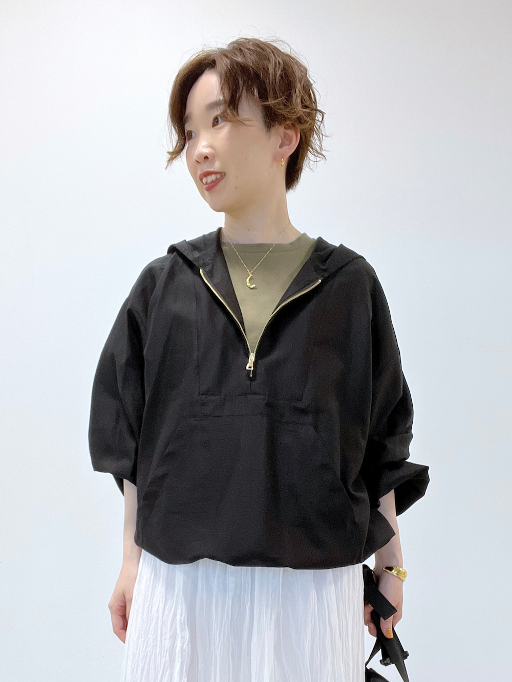 ホワイト系のスカート、ブラック系のシャツ/ブラウス、グリーン系のTシャツ/カットソーを着用したレディースの夏コーディネートの2枚目の写真