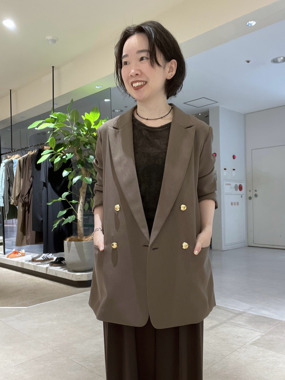 ブラウン系のスラックス、ブラック系のパンプス、ブラウン系のTシャツ/カットソーを着用したレディースの秋コーディネートの5枚目の写真