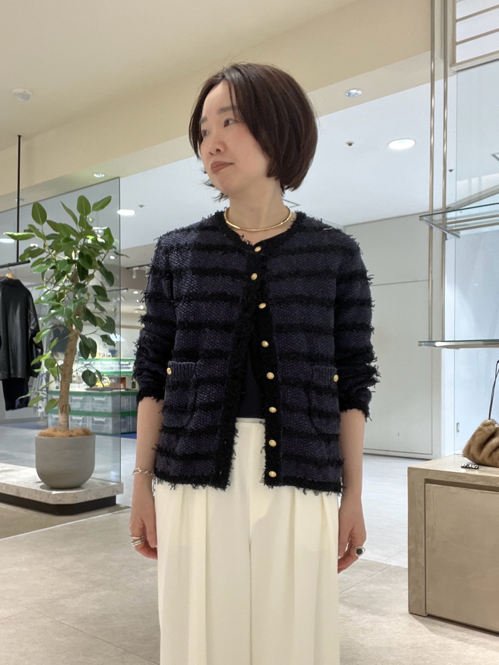 ブルー系のカーディガン/ボレロ、ホワイト系のスラックス、ブルー系のシャツ/ブラウスを着用したレディースの冬コーディネートの4枚目の写真