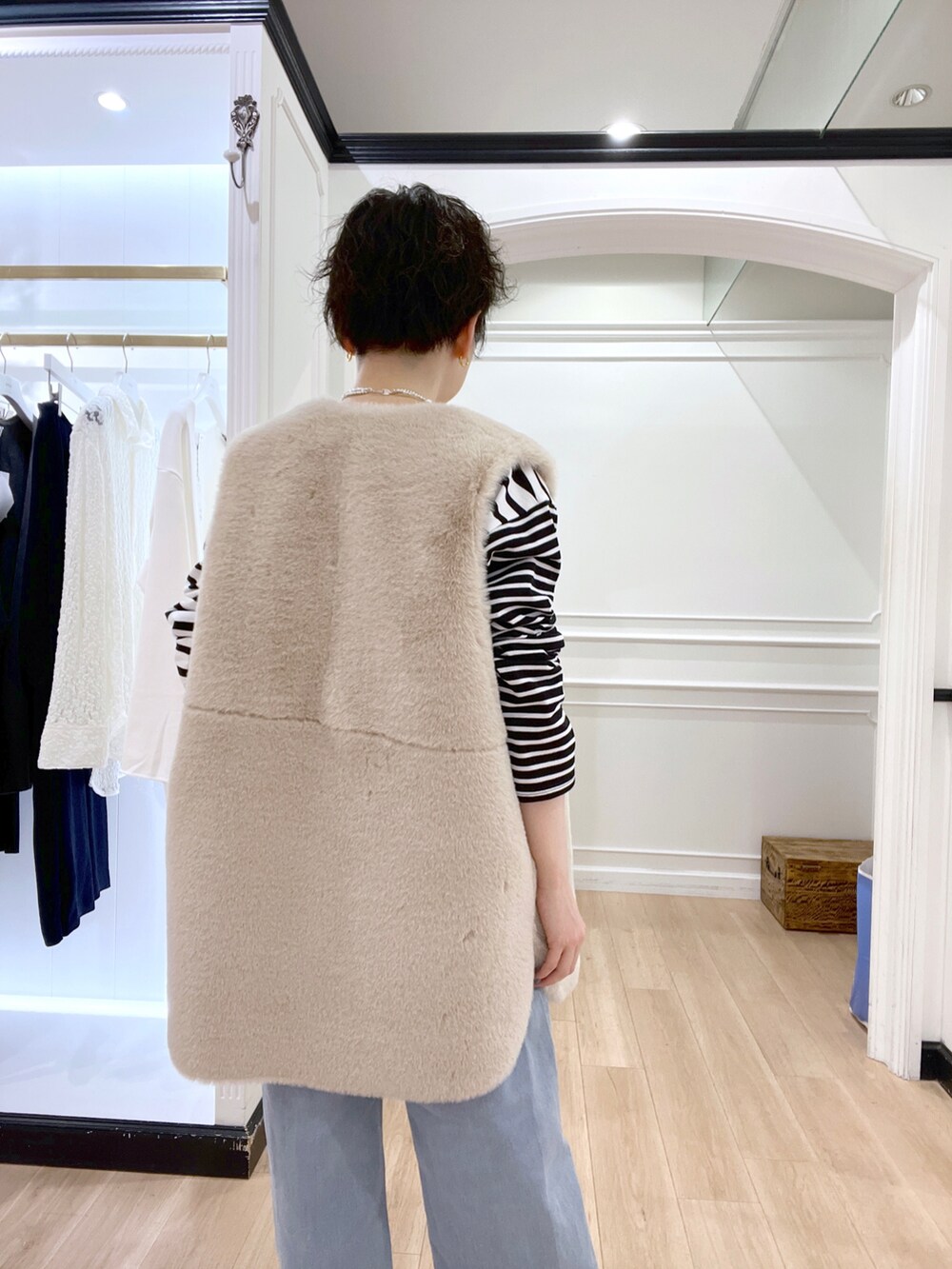 ブラック系のブーツ、ホワイト系のベスト、ブラック系のTシャツ/カットソーを着用したレディースの冬コーディネートの4枚目の写真