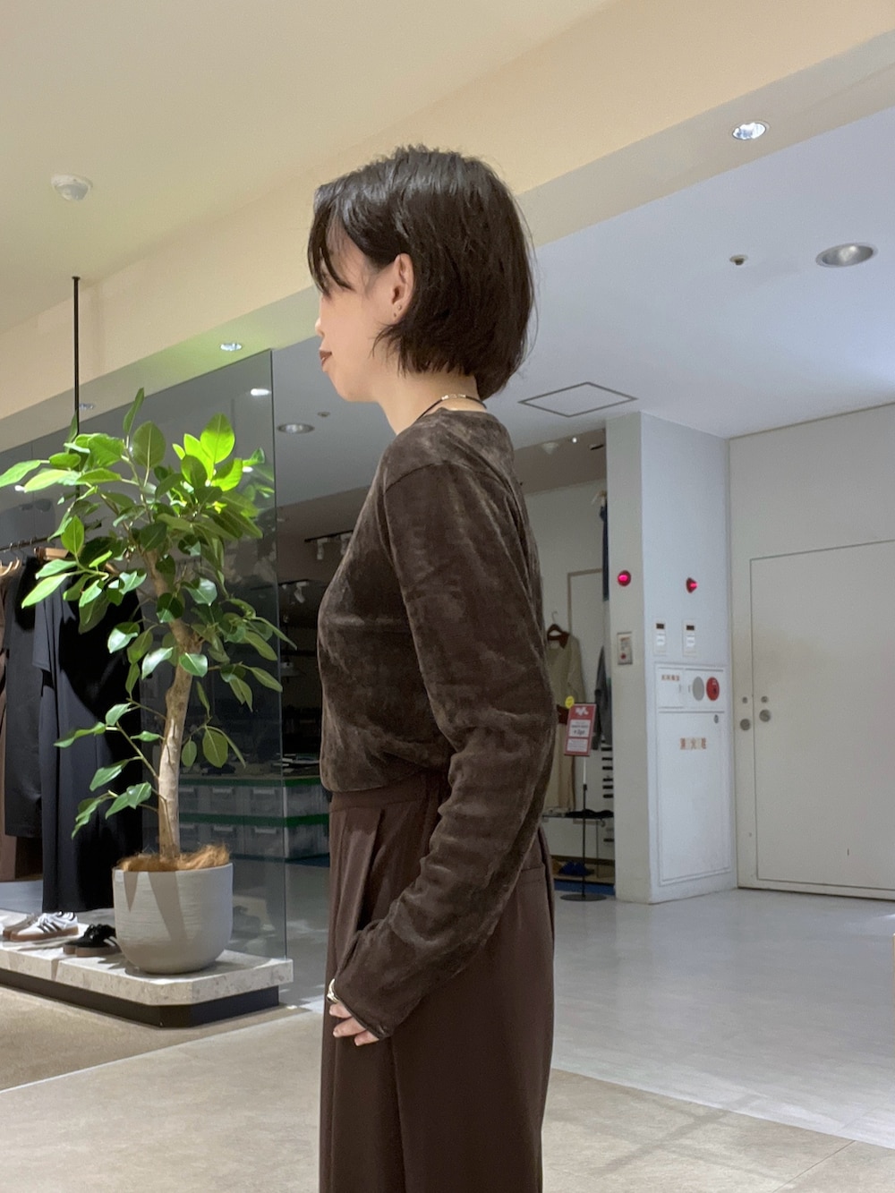 ブラウン系のスラックス、ブラック系のパンプス、ブラウン系のTシャツ/カットソーを着用したレディースの秋コーディネートの9枚目の写真