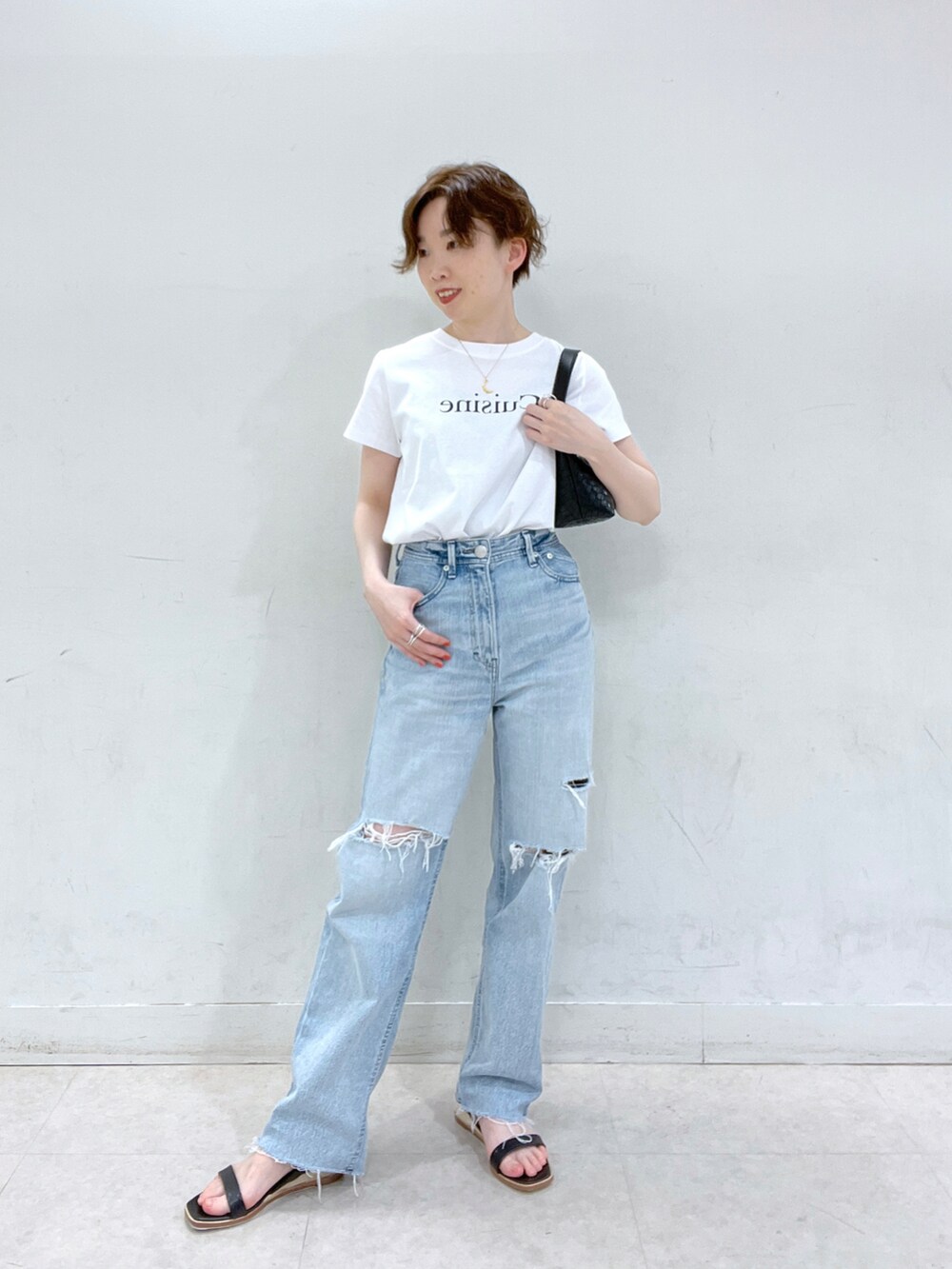 ブルー系のデニムパンツ、ベージュ系のテーラードジャケット、ホワイト系のTシャツ/カットソーを着用したレディースの春コーディネートの3枚目の写真