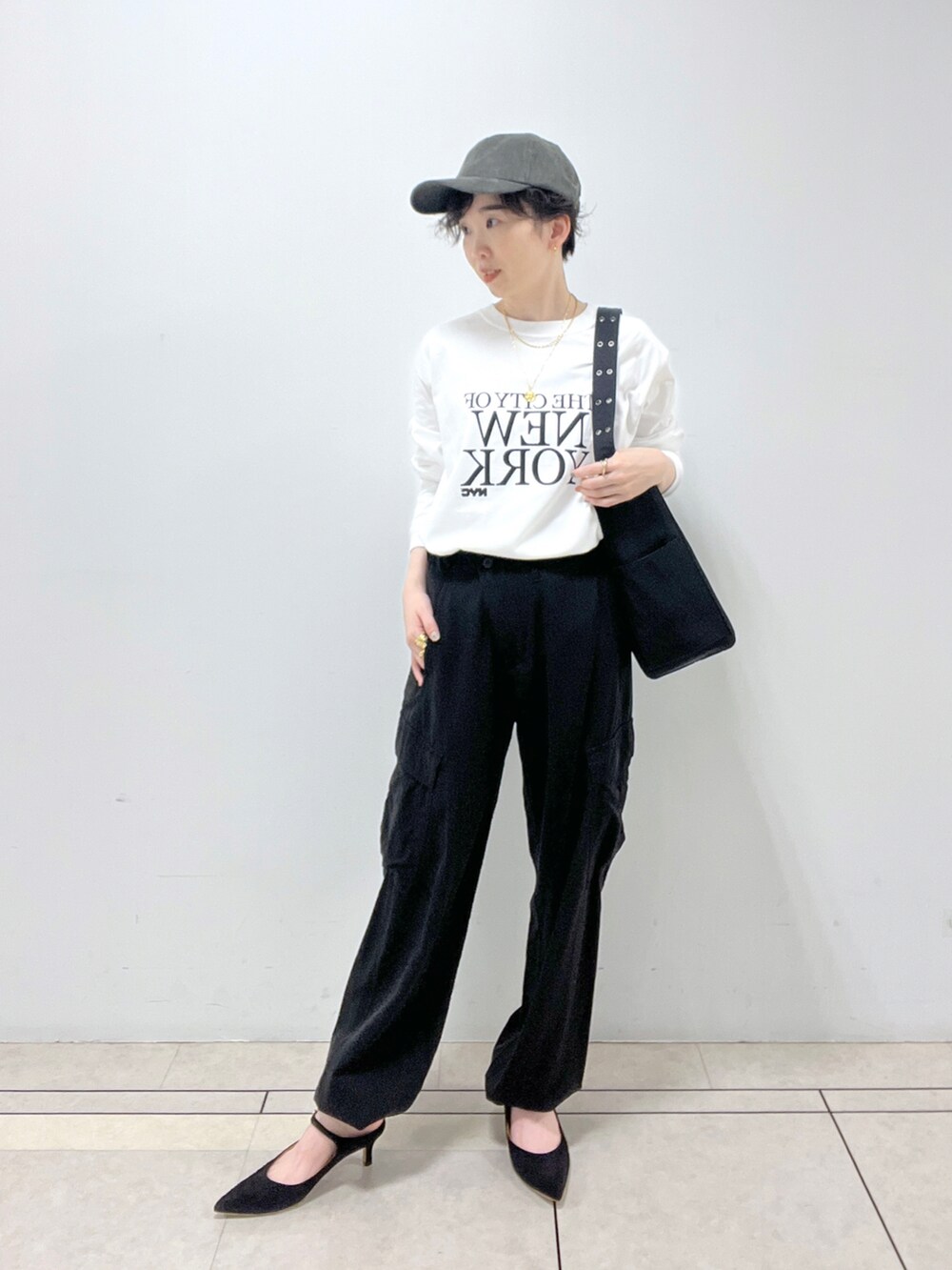 ブラック系のカーゴパンツ、ベージュ系のノーカラーコート、ホワイト系のTシャツ/カットソーを着用したレディースの秋コーディネートの3枚目の写真