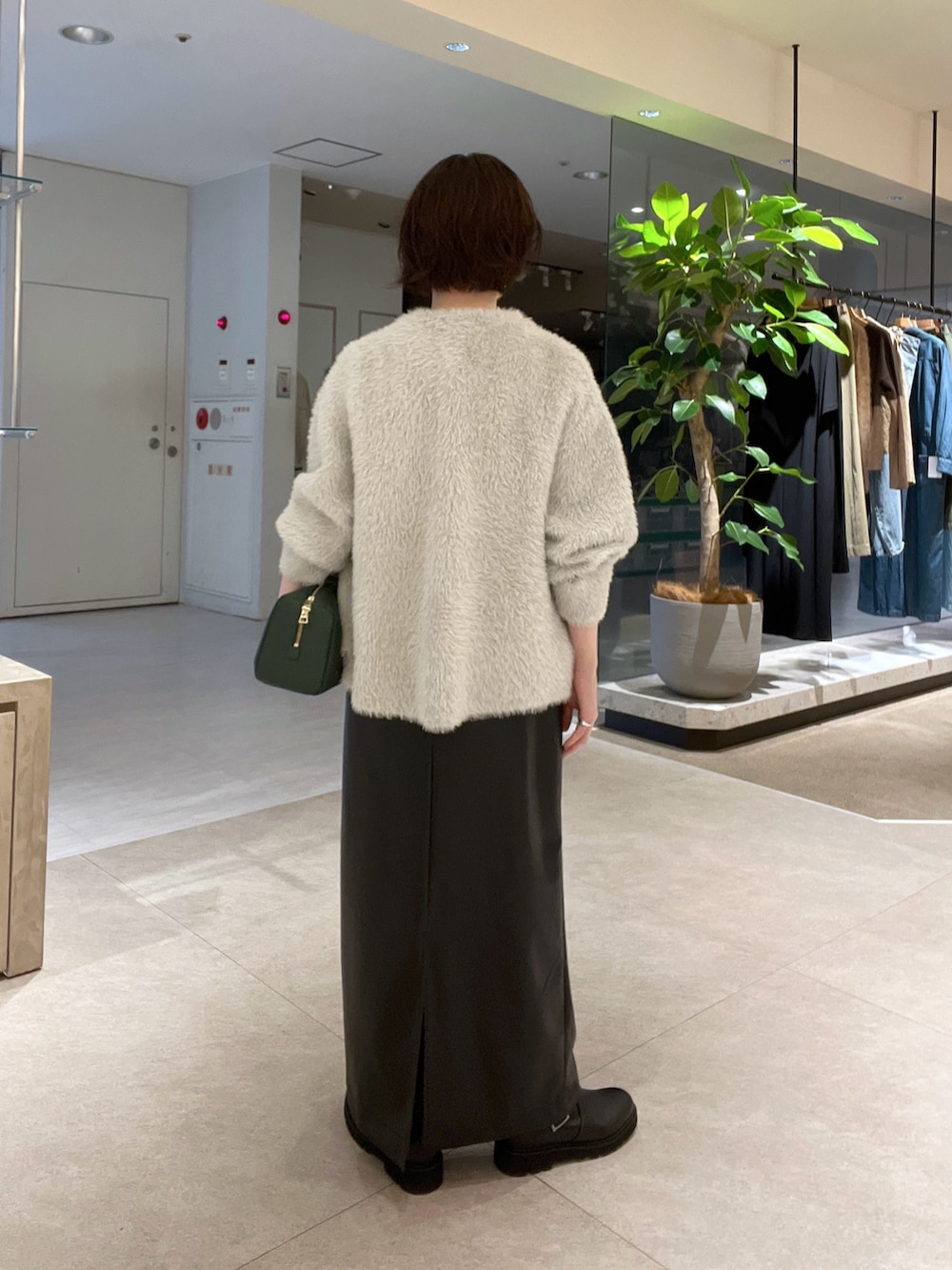 ベージュ系のカーディガン/ボレロ、ブラック系のスカート、ホワイト系のTシャツ/カットソーを着用したレディースの秋コーディネートの3枚目の写真