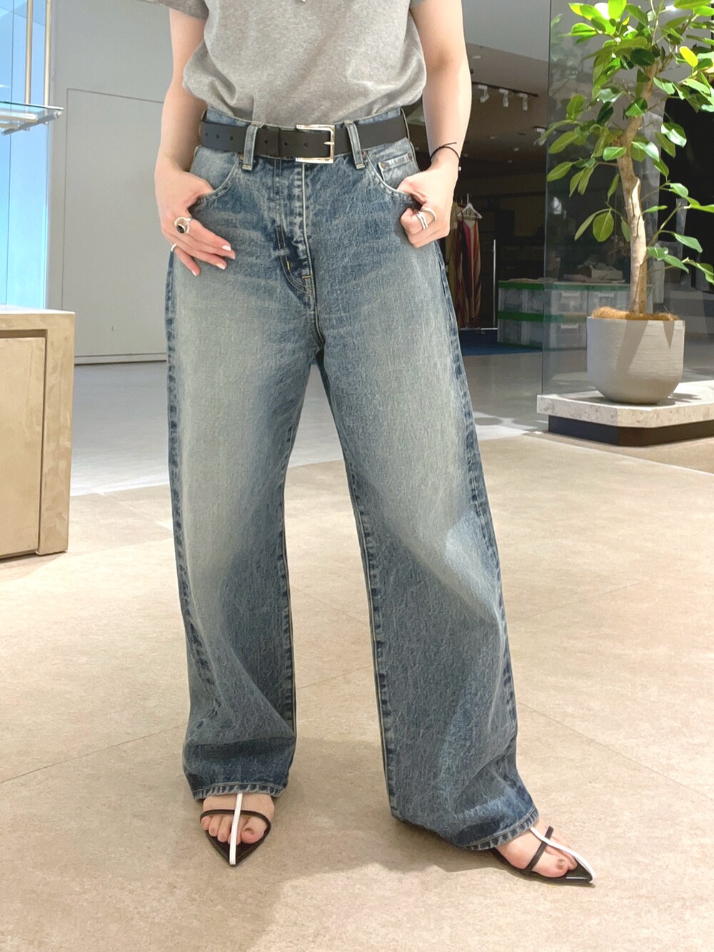 ブルー系のデニムパンツ、ブラック系のサンダル、グレー系のTシャツ/カットソーを着用したレディースの夏コーディネートの7枚目の写真