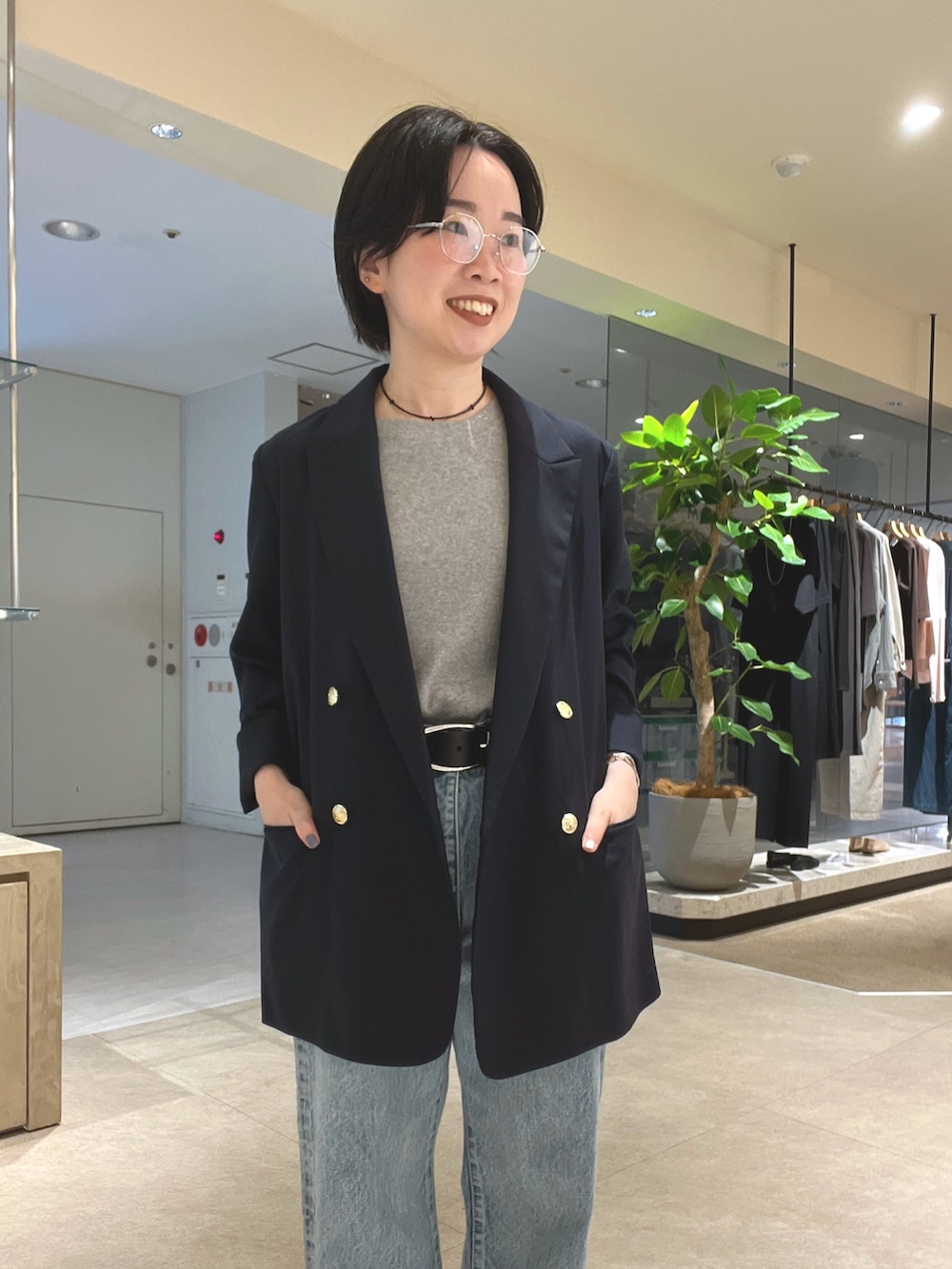 ブルー系のデニムパンツ、ブラック系のパンプス、ブラック系のボストンバッグを着用したレディースの夏コーディネートの4枚目の写真