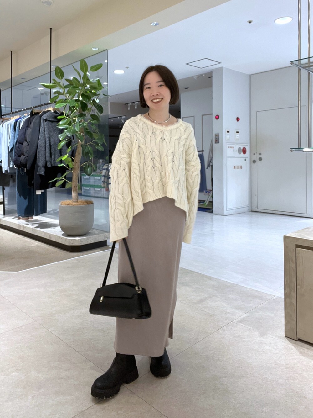 ベージュ系のその他アウター、ホワイト系のニット/セーター、ベージュ系のワンピースを着用したレディースの冬コーディネートの7枚目の写真