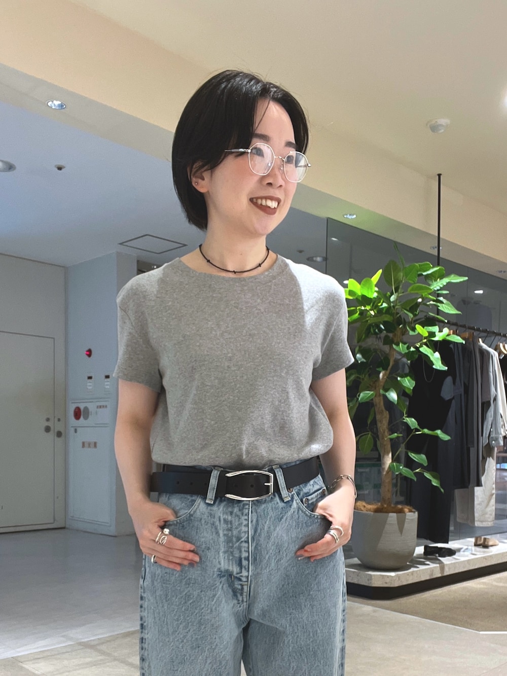ブルー系のデニムパンツ、ブラック系のパンプス、ブラック系のボストンバッグを着用したレディースの夏コーディネートの7枚目の写真