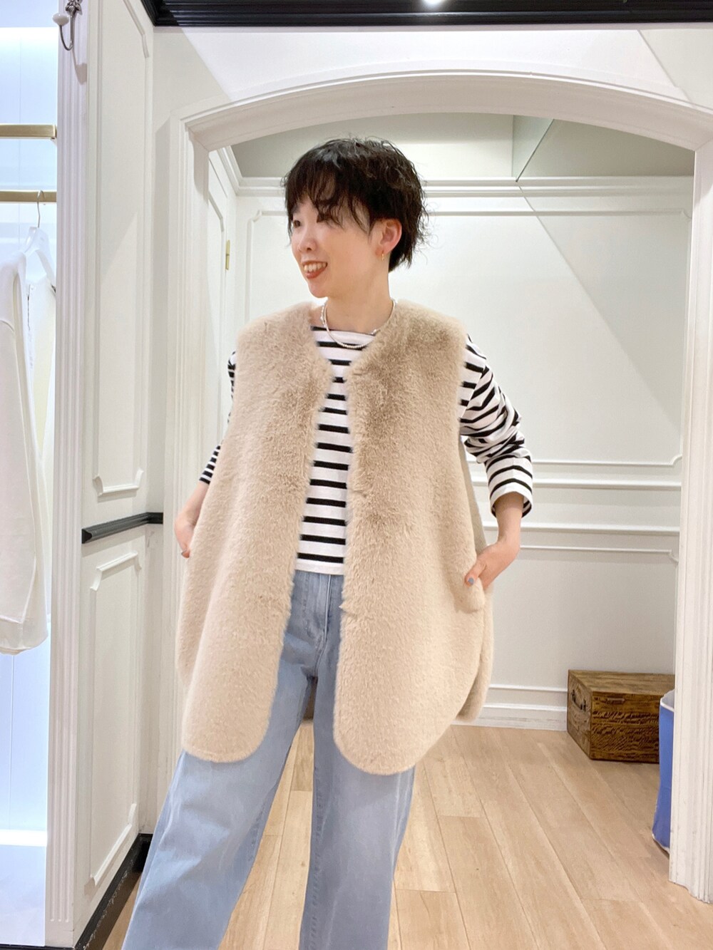 ブラック系のブーツ、ホワイト系のベスト、ブラック系のTシャツ/カットソーを着用したレディースの冬コーディネートの3枚目の写真