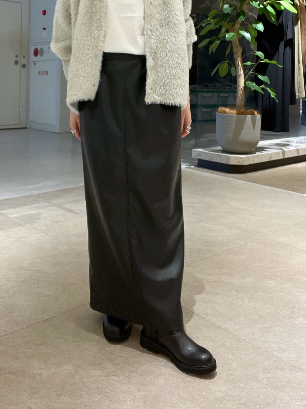 ベージュ系のカーディガン/ボレロ、ブラック系のスカート、ホワイト系のTシャツ/カットソーを着用したレディースの秋コーディネートの8枚目の写真