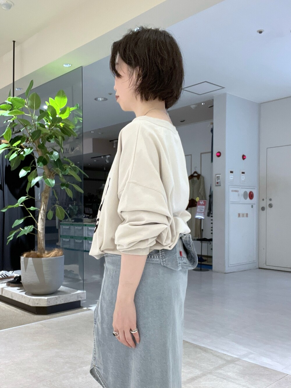 ブラウン系のスラックス、ホワイト系のスウェット、ブラック系のバックパック/リュックを着用したレディースの秋コーディネートの4枚目の写真