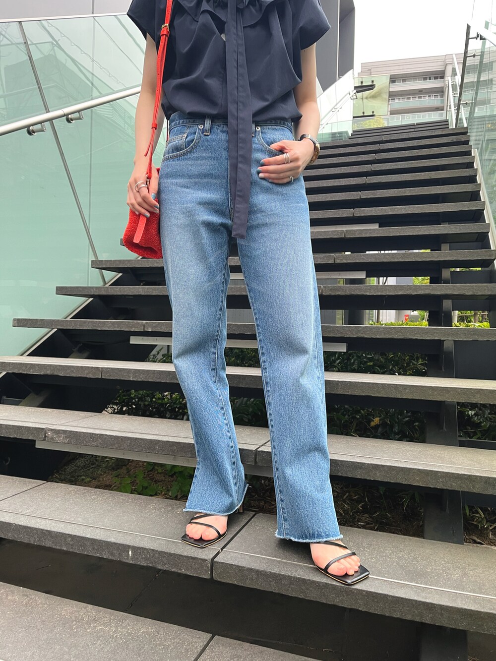 ブルー系のデニムパンツ、ブルー系のシャツ/ブラウス、ブラック系のサンダルを着用したレディースの春コーディネートの3枚目の写真