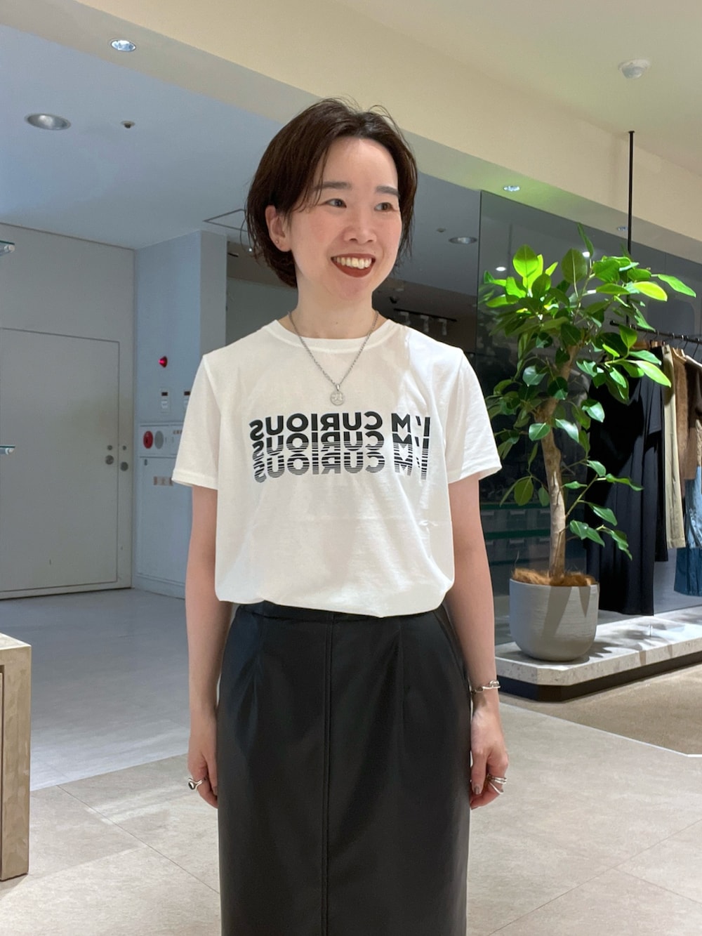 ベージュ系のカーディガン/ボレロ、ブラック系のスカート、ホワイト系のTシャツ/カットソーを着用したレディースの秋コーディネートの7枚目の写真