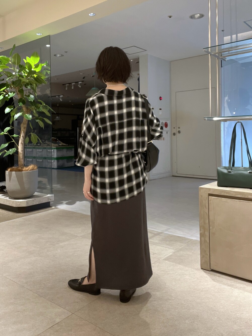 ブラック系のシャツ/ブラウス、グレー系のワンピース、ブラック系のローファーを着用したレディースの秋コーディネートの3枚目の写真