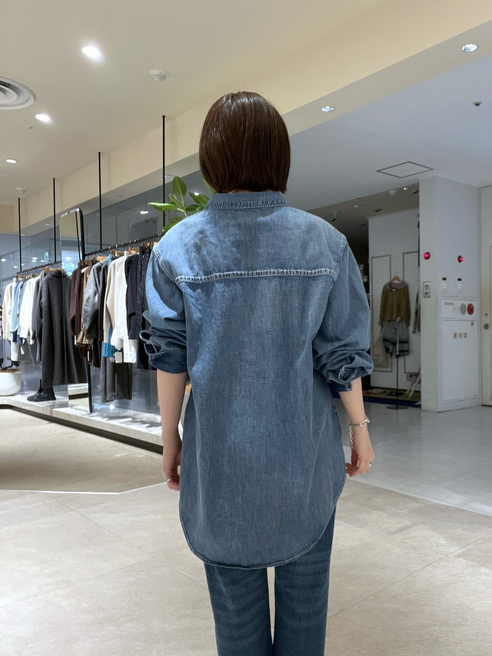 ブルー系のシャツ/ブラウス、ブルー系のデニムパンツ、イエロー系のボストンバッグを着用したレディースの冬コーディネートの6枚目の写真