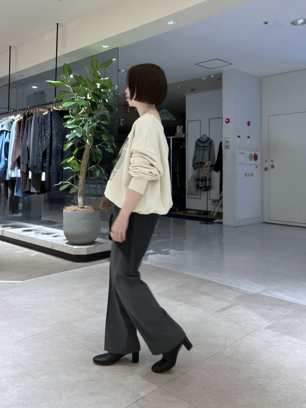 ホワイト系のTシャツ/カットソー、グレー系のその他パンツ、ブラック系のブーツを着用したレディースの冬コーディネートの2枚目の写真